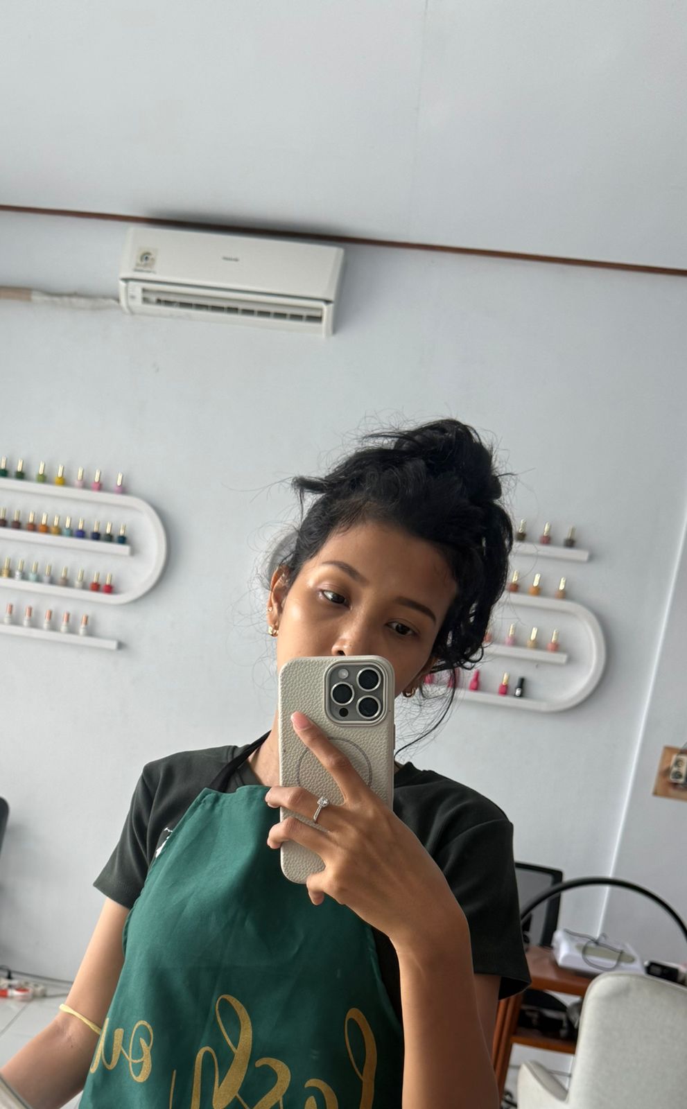 Lina the nail technician at Lollygagss Studio with nail polish wall